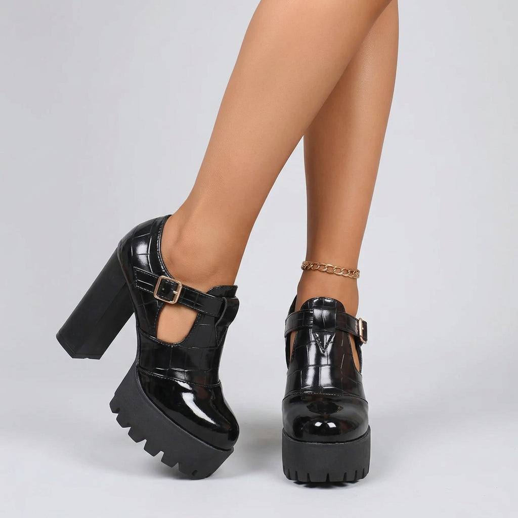 A pair of green and black platform pump shoes with chunky heels and a square toe style.